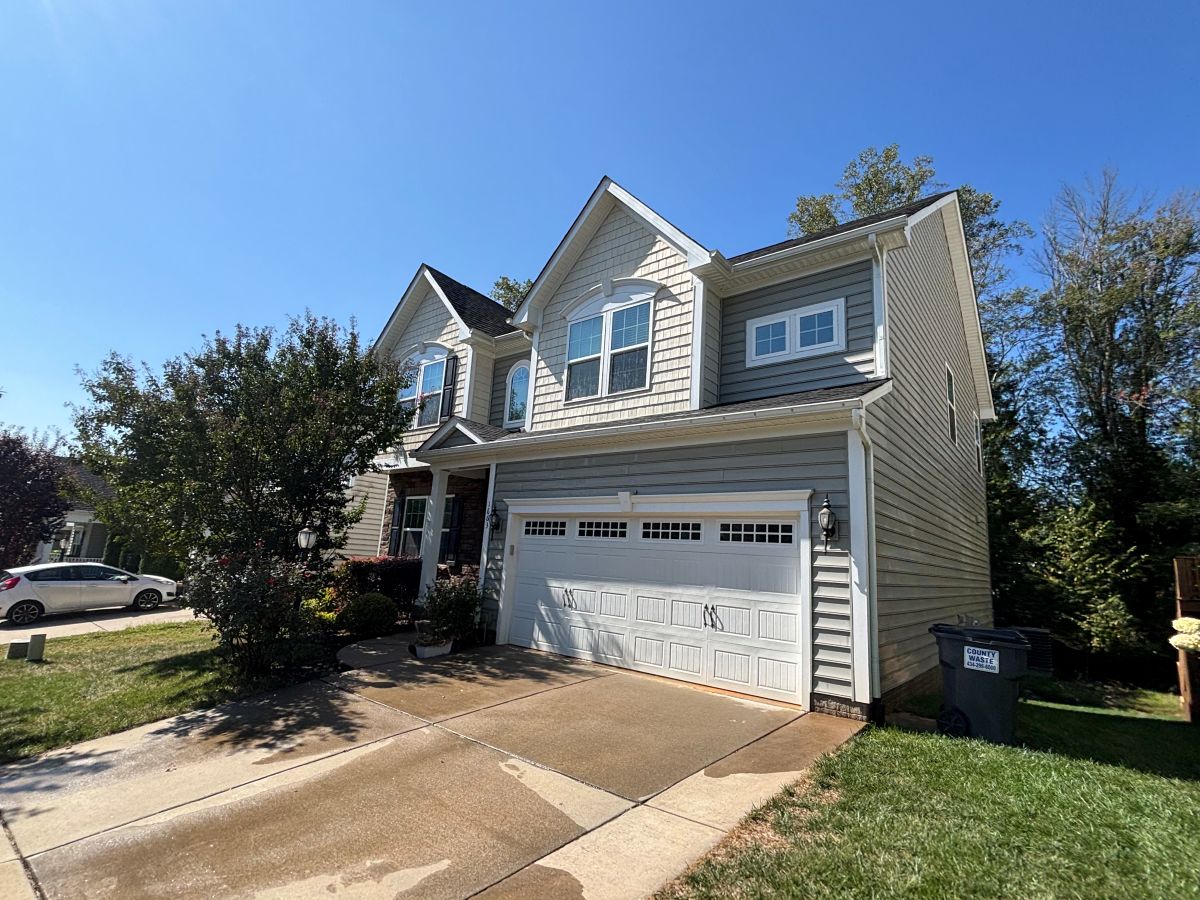 Two-story home with clean vinyl siding and washed concrete driveway in Charlottesville, Virginia